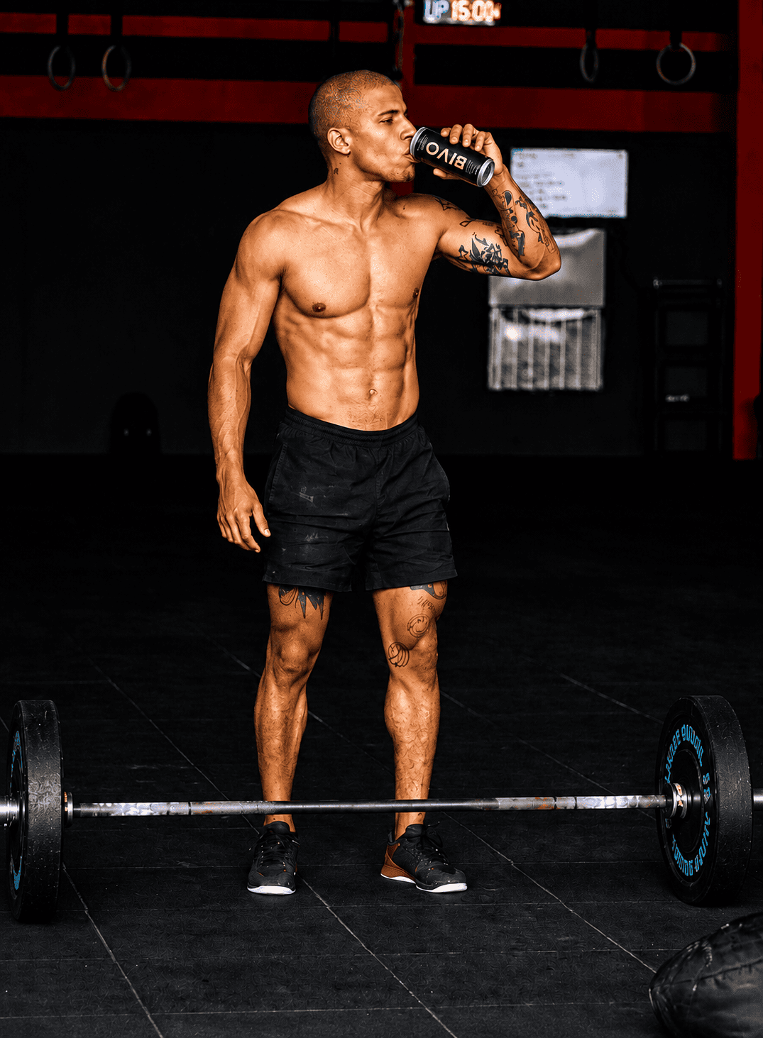 Hombre deportista bebiendo bivo mientras hace crossfit